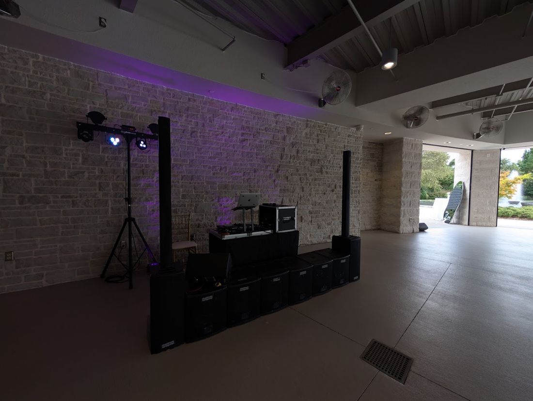 Gig Bar lights and speakers set up against a brick wall with purple uplighting