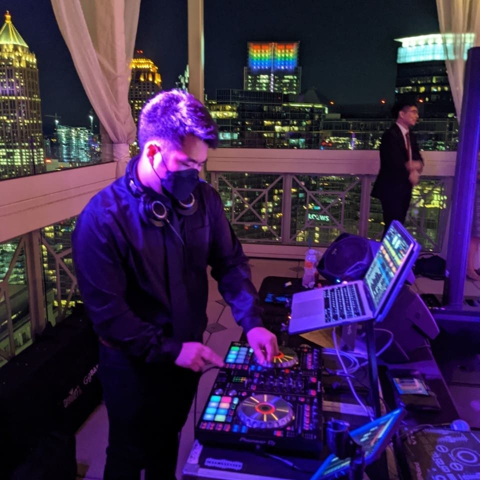 David at the decks at a rooftop event, Atlanta skyline behind him