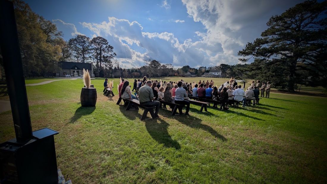 Column speaker beside an open-air lawn ceremony