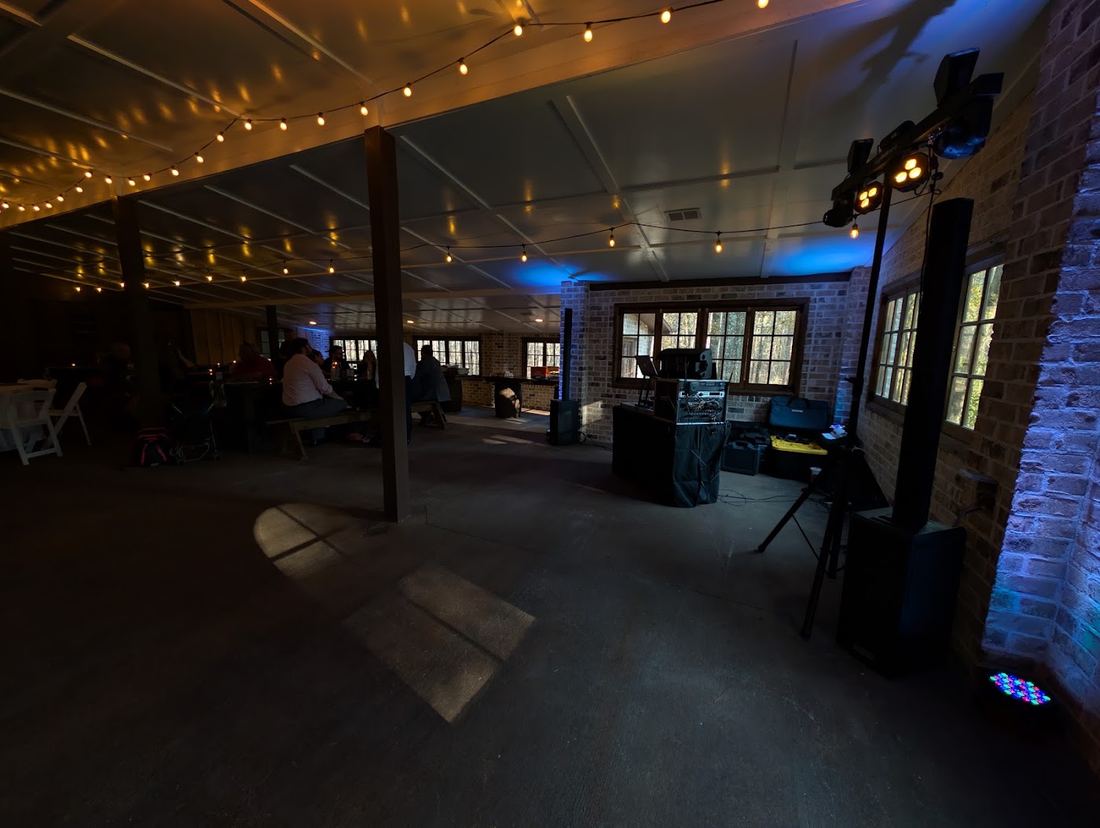 Rustic venue with string lights and uplighting